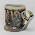 Soda-fired Ceramic mug with speckled and handle on a white background