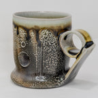 Soda-fired Ceramic mug with speckled and handle on a white background