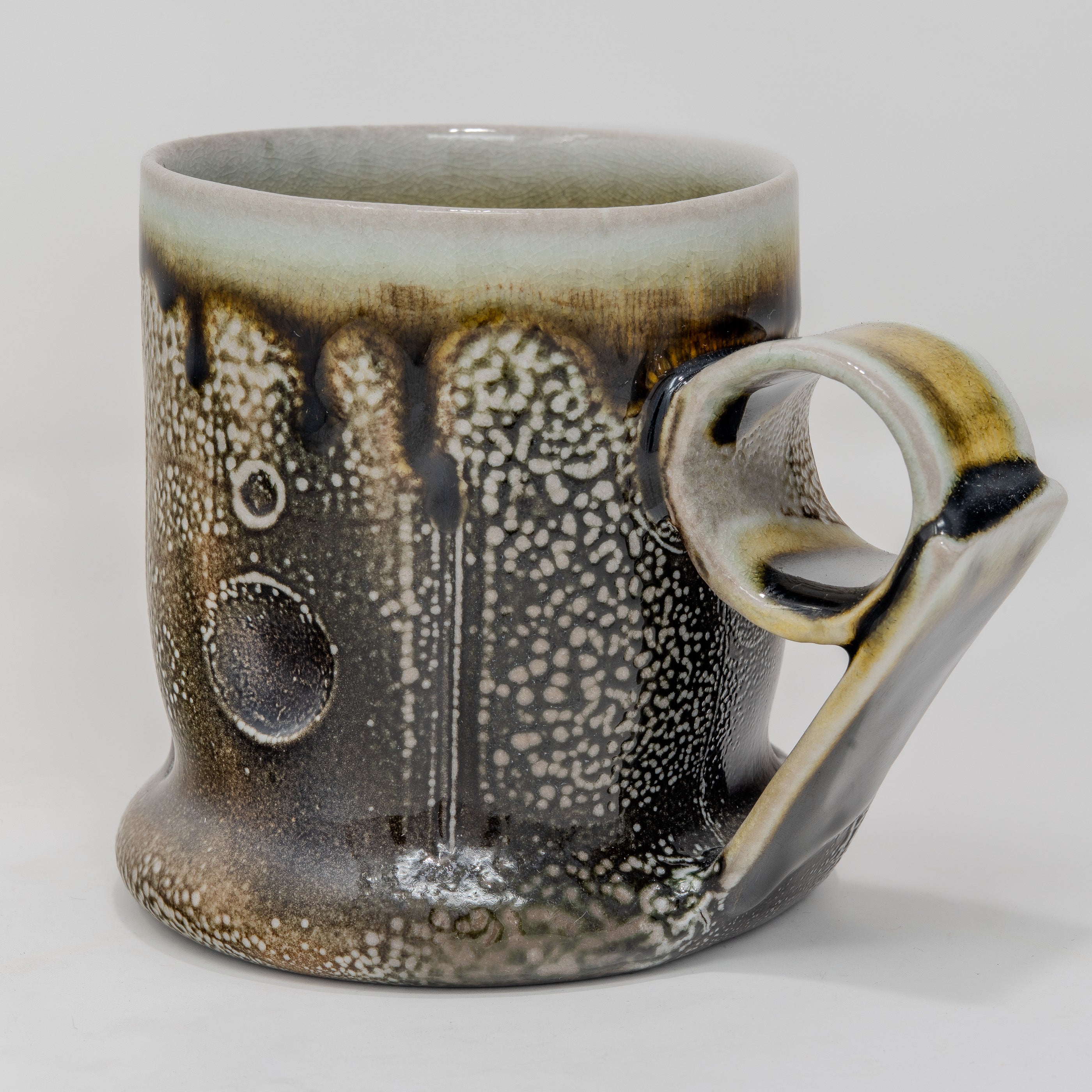 Soda-fired Ceramic mug with speckled and handle on a white background